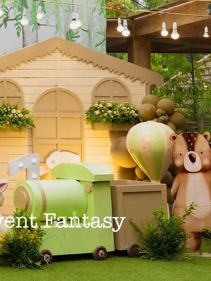 A charming wooden train prop as part of Ryne's woodland party. This piece adds a playful touch, surrounded by animal cutouts and a hot air balloon, making the scene feel like a storybook illustration.