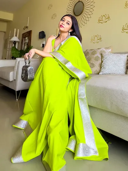 The vibrant neon green saree in a different pose, showing how the color brightens up the room. It’s a happy, confident color perfect for celebrations.
