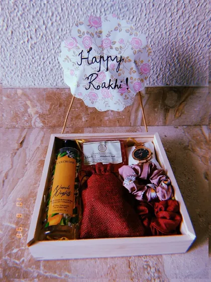 Make your sister feel cherished with a custom Rakhi hamper. This thoughtful gift set in a wooden tray includes a beautiful watch, scrunchies, and skincare items from The Body Shop, all chosen to make her feel pampered and loved.