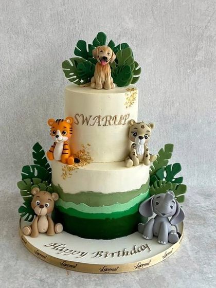 A jungle-themed cake for Swarup's birthday. This two-tiered cake features a soft green ombre and is decorated with a whole family of cute, handmade fondant animals.