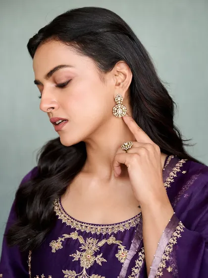 Shraddha Srinath looks radiant in this deep purple salwar suit for her movie promotions. The gold embroidery provides a rich contrast, making it a regal and elegant look for any formal occasion.