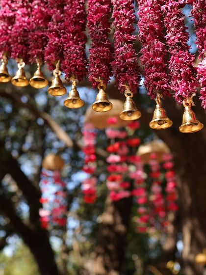 A close up of the hanging floral decor. We added small brass bells to the magenta flower strings, so they would create a gentle, musical chime as guests walked past.