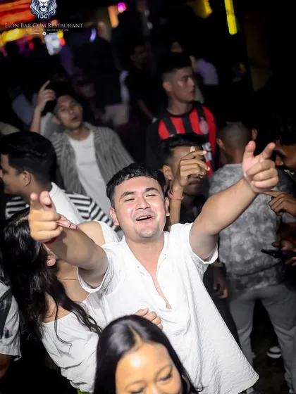 A guest enjoying the vibe and pointing at the camera, fully engaged in the party.