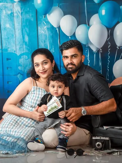 A family portrait where the parents and their "Boss Baby" pose with a prop dollar bill.