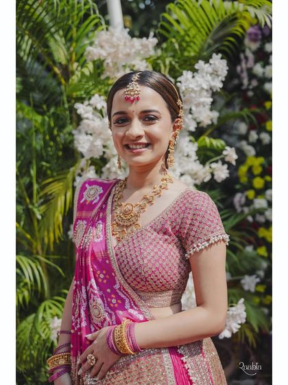 A lovely solo shot of the bride. Her traditional bandhej dupatta adds a classic touch to the bright and festive pink lehenga, perfect for a daytime ceremony.