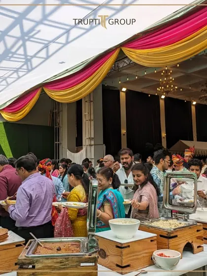 Where every bite tells a story and every moment is a celebration. A wide shot of guests enjoying our buffet at a beautifully decorated wedding hall.