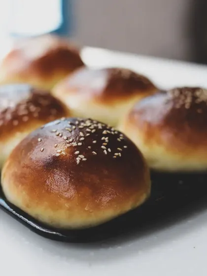 Another shot of our homemade burger buns, shiny and topped with sesame seeds.
