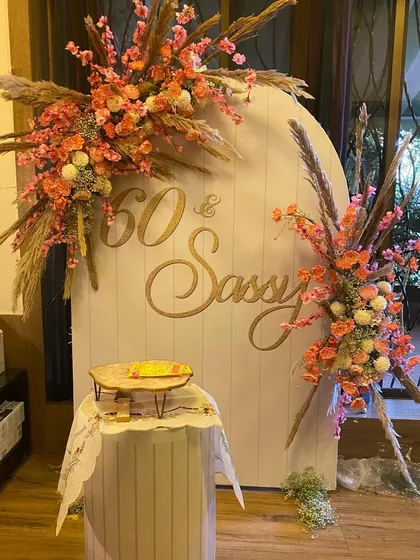 Celebrating 60 years in style with our "60 & Sassy" setup. This elegant design features a beautiful arched backdrop adorned with lush, vibrant floral arrangements and pampas grass, creating a sophisticated and picture-perfect spot for a milestone birthday bash.