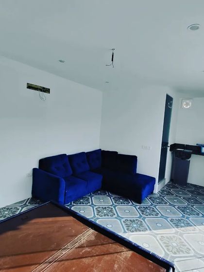 This image shows the living area of a prefab room, complete with a sofa and provisions for air conditioning and other electricals. We can configure the space to your needs.