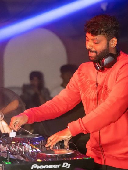 In the mix with a red sweatshirt, feeling the energy of the room. Every set is a chance to create something special.