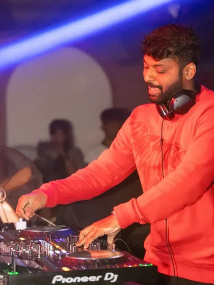 In the mix with a red sweatshirt, feeling the energy of the room. Every set is a chance to create something special.