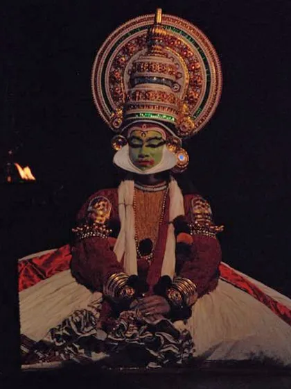 A seated pose as Arjuna, listening intently. Kathakali places immense emphasis on 'abhinaya' or facial expression, with subtle movements of the eyes and brows conveying complex emotions.