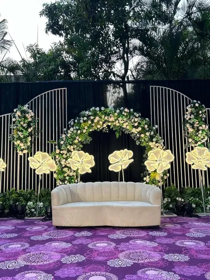 A full view of our Indian-themed stage decor, featuring a floral arch, illuminated flowers, and a rich purple carpet. This setup is perfect for a vibrant reception or Sangeet night.