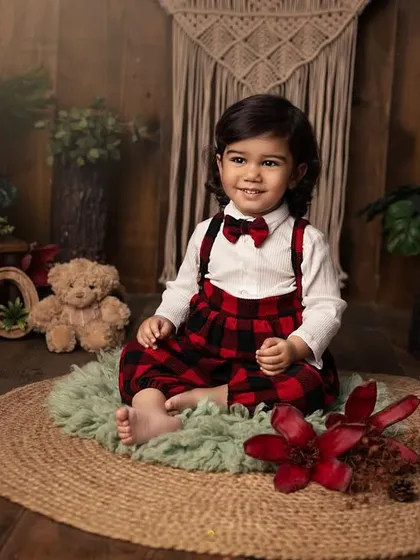 A sweet, gentle smile from our two-year-old. The warm, wooden backdrop and rustic props create a cozy and timeless setting for his birthday portraits.