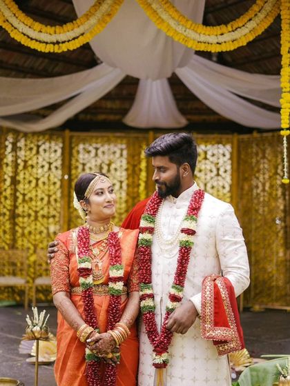 A classic portrait of Sneha and Pranav after their ceremony, adorned with beautiful garlands. Their matching smiles reflect their happiness.