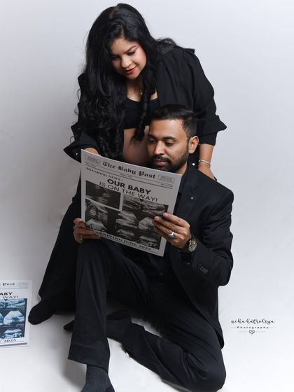 This candid-style shot captures the couple sharing a moment while reading their special "Baby Post" newspaper. It’s these unposed, interactive moments that often become the most cherished photographs.