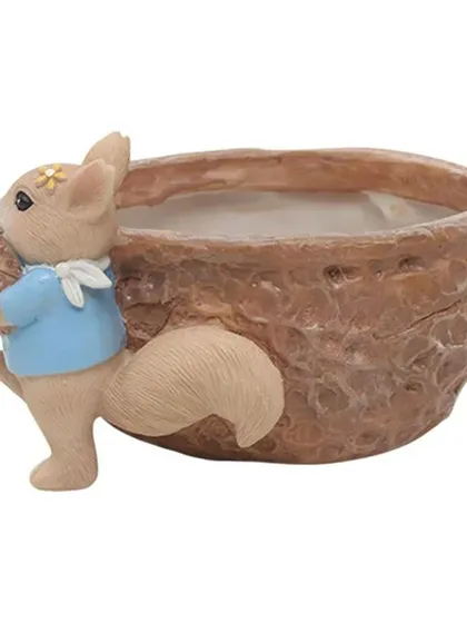 A side view of the squirrel nut resin pot. The detailed texture of the nut and the sweet expression on the squirrel make it a delightful piece of decor.