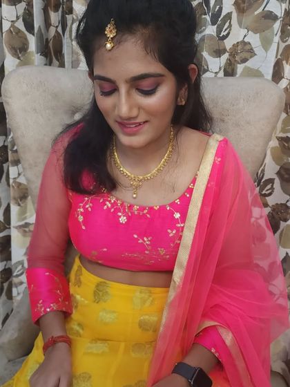 A close-up of the daughter's makeup, featuring a pop of pink on the eyes to match her vibrant outfit.