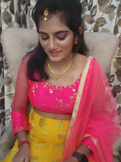 A close-up of the daughter's makeup, featuring a pop of pink on the eyes to match her vibrant outfit.