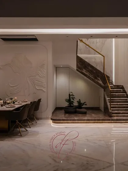 A grand staircase can be the soul of a home. For this duplex, we designed a 26-foot high book-matched marble wall, accented with ceramic and metal art. The automated, motion-sensing lights on the steps add a touch of modern magic, blending artistry with technology.