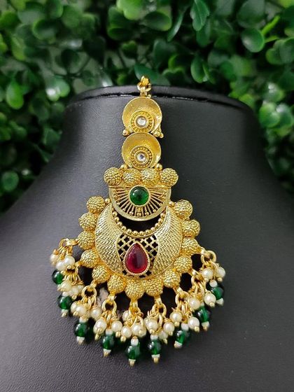 Another variation of a traditional gold-finish maang tikka with a crescent design.