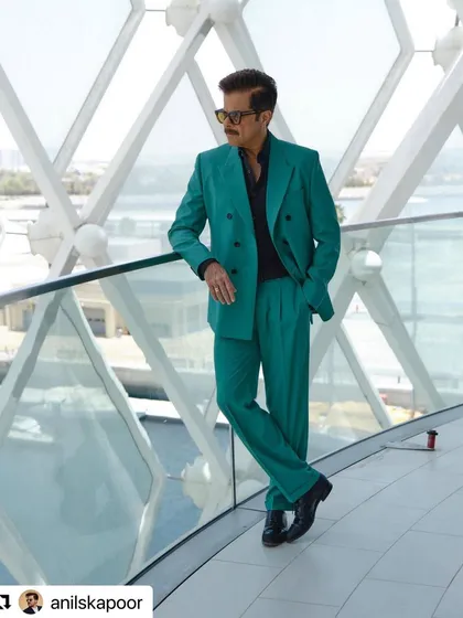 The full look against a stunning backdrop. The vibrant suit is balanced by the classic, sharp haircut.