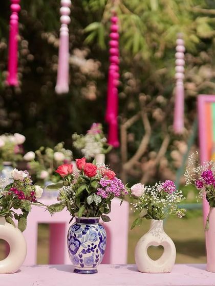 Detail shot of the decor elements at the pink Rajasthani Mehendi, including custom vases and floral arrangements that complement the vibrant theme.
