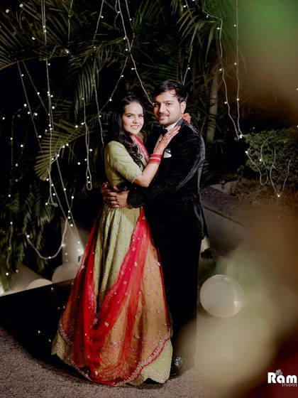 A happy couple portrait from an outdoor engagement party. The fairy lights in the trees add a whimsical touch to this celebratory photograph.