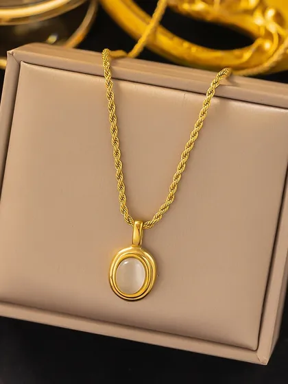 This classic necklace features a beautiful white oval stone in a simple gold-tone setting on a rope chain. It's a timeless piece made from guaranteed stainless steel.