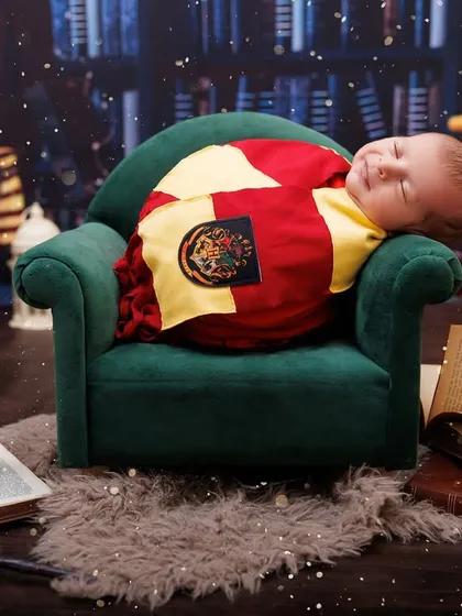 A magical smile from a sleeping baby in a full Harry Potter themed setup, complete with books and candles.