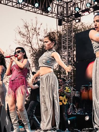 A close-up action shot from the stage, capturing the energy and connection between the lead singer and our backup dancers during a live music festival.