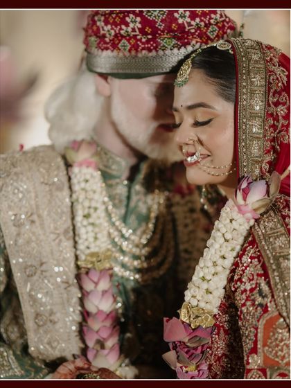 A close-up filled with emotion and tradition. The groom gently holds the bride, their expressions soft and loving, surrounded by the rich colors and textures of their wedding attire in Jaipur.
