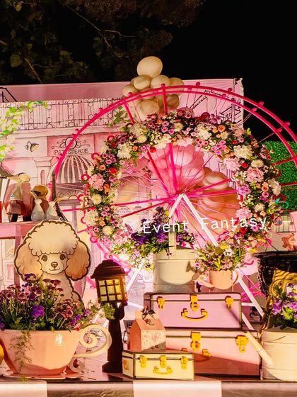 A detailed shot of the Parisian party decor, featuring a large floral Ferris wheel and a poodle cutout.