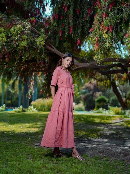 A classic portrait pose that showcases the dress and the model's happy expression in a beautiful, naturally lit park setting.