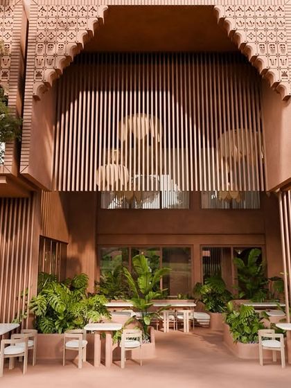The outdoor seating area of the restaurant, set against the building's stunning facade with its intricate arches and fluted walls.