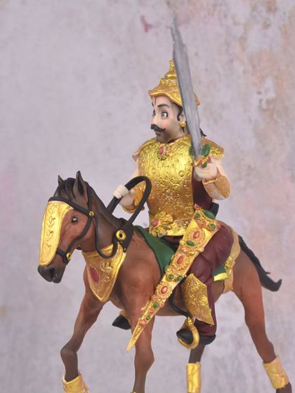 A side profile of the king and his horse. Every detail, from the jeweled scabbard to the intricate armor, was carefully crafted and painted by hand.