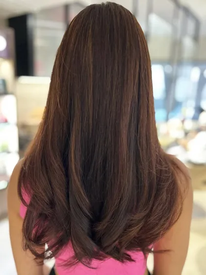 A warm auburn caramel blend that adds richness and shine. This is a great example of a warm brown hair color with blended highlights.