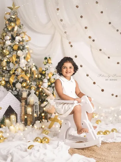 A little girl enjoying a ride on a rocking horse in a magical, snowy Christmas scene.