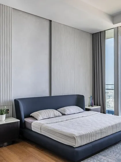 This view showcases the bedroom's connection to the outdoors, with floor-to-ceiling windows flooding the space with natural light. The minimalist design ensures the focus remains on the expansive view and the room's tranquil atmosphere.