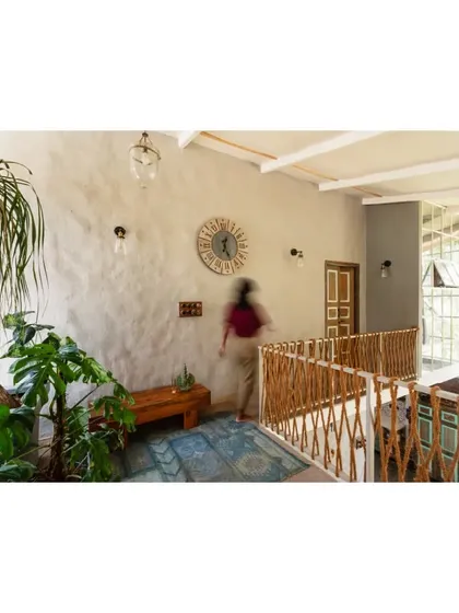 A wider view of the jute railing and lime-plastered walls. This space integrates many environmentally friendly elements, from upcycled wood doors to vintage-style switch boxes.