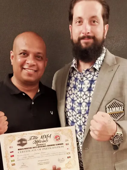 Posing with the head of AIMMAA after successfully completing the Elite MMA Official certification. We are committed to excellence.
