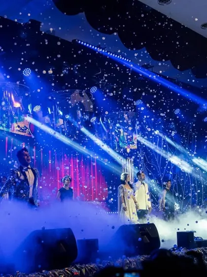 We design sangeet nights that feel like world class concerts. This shot captures the energy of a grand performance, complete with professional stage lighting, atmospheric effects, and a custom built stage that set the tone for an electrifying evening of celebration.