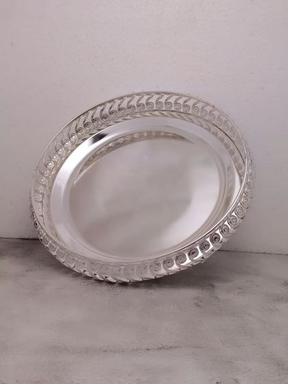 A simple yet elegant German silver tray with a braided design on the edge. It's a versatile piece for any occasion.