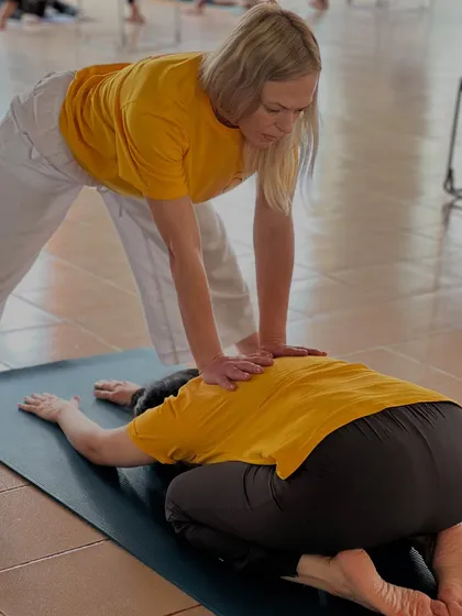 In our Advanced TTC, we practice the principle of "Help thy neighbor as thyself." Here, a teacher provides a gentle adjustment to a student in Balasana, the child's pose, ensuring deep relaxation.
