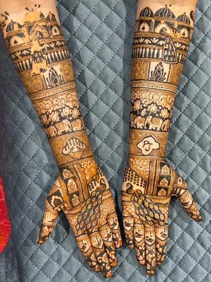 This full-arm bridal design is a masterpiece of symmetry and detail. It features personalized initials, elephant motifs, and palace-inspired architecture, all woven together with classic jaali (net) patterns.
