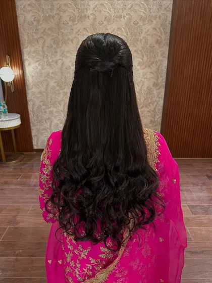 A view of the sleek and elegant half-up, half-down hairstyle, which perfectly complements the graceful makeup look.