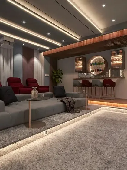 A high-end home entertainment room featuring plush recliner seats, a comfortable sofa, and a built-in bar. The floor and ceiling lighting create a sophisticated and immersive atmosphere.