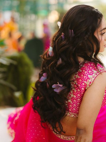 A close-up of Shree's Mehendi hairstyle, with delicate flowers woven into her soft waves. It's these small details that complete the look.