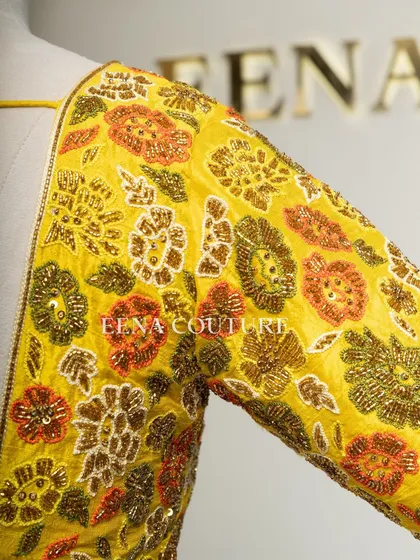 Another take on the yellow raw silk blouse, this piece features a classic Katori cut. The front is kept simple to highlight the fit, while the back and sleeves are adorned with a vibrant floral pattern in multi-colored beadwork.