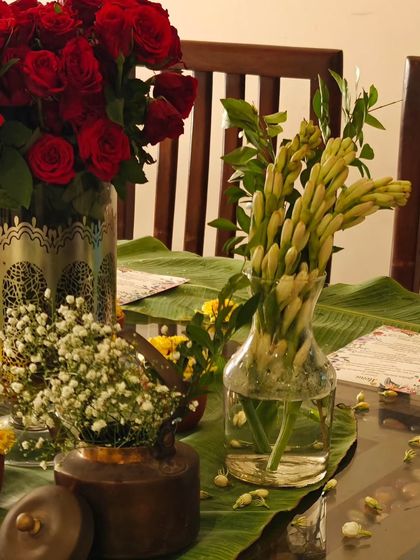 Fresh flowers are a must for my table settings. Here, red roses and tuberoses add a touch of elegance and fragrance to the dining experience, making it feel extra special.